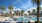 a pool with palm trees and a building in the background